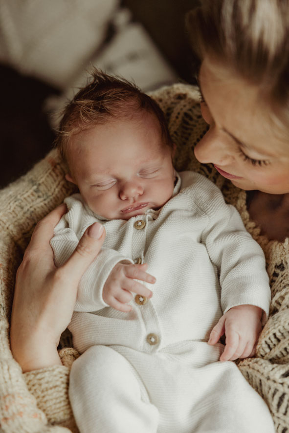 Nieuwe mama met haar zoontje in haar armen tijdens een newbornshoot